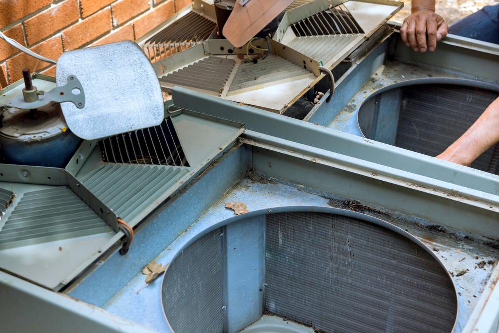 Homeowner using an AC repair guide to troubleshoot common air conditioning problems